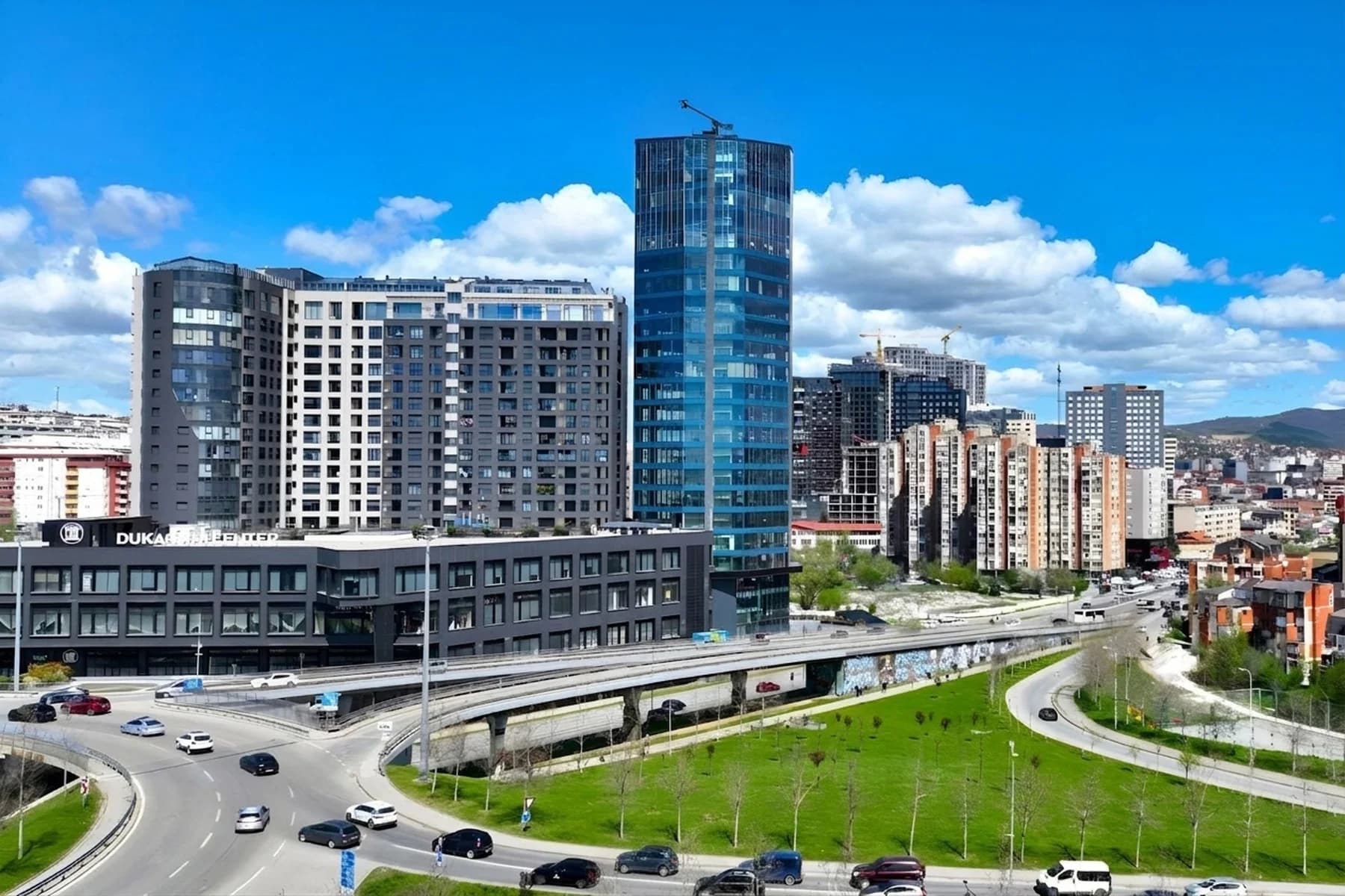 The Dukagjini Center in Pristina, against a clear sky, on the road into the city