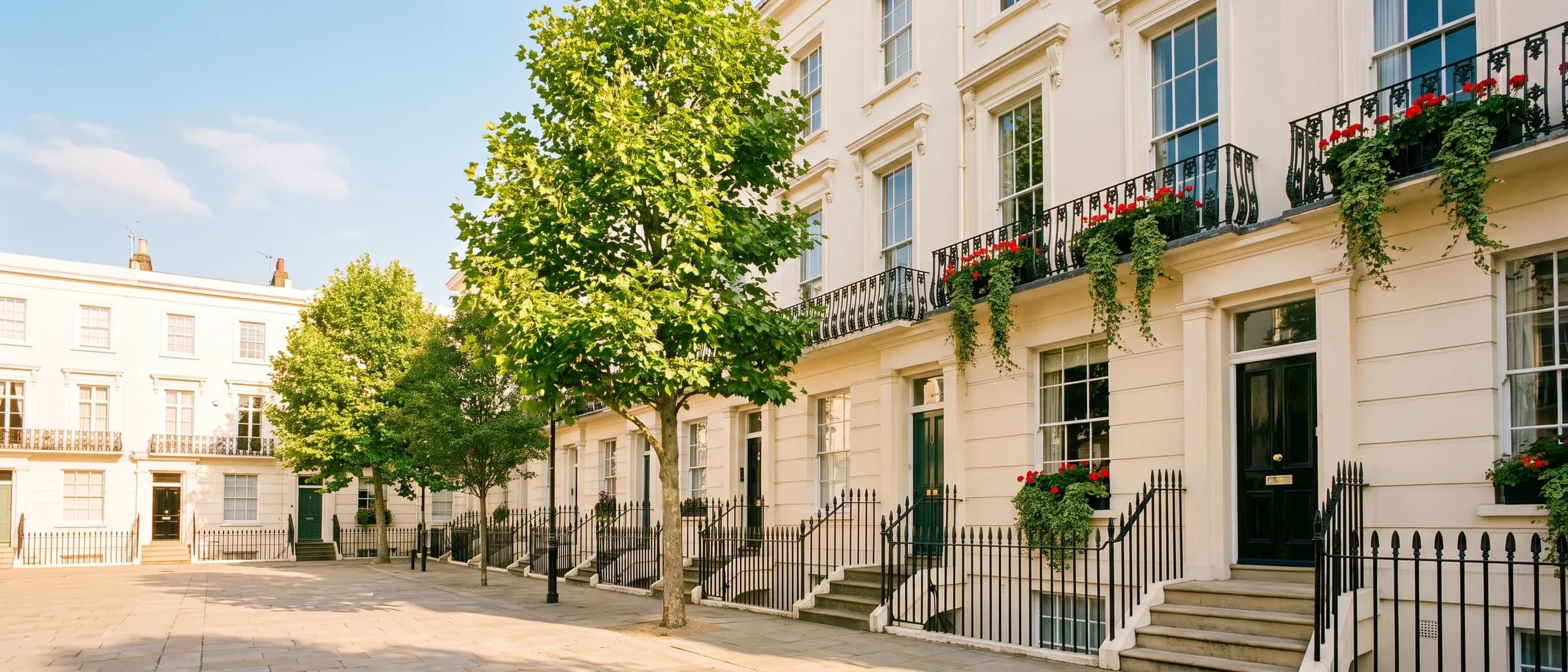 A terrace of cream stucco London townhouses in warm morning light, railings and window boxes along the street